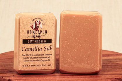 Goat milk soap bar with 'Homespun Chick' packaging on a wooden surface