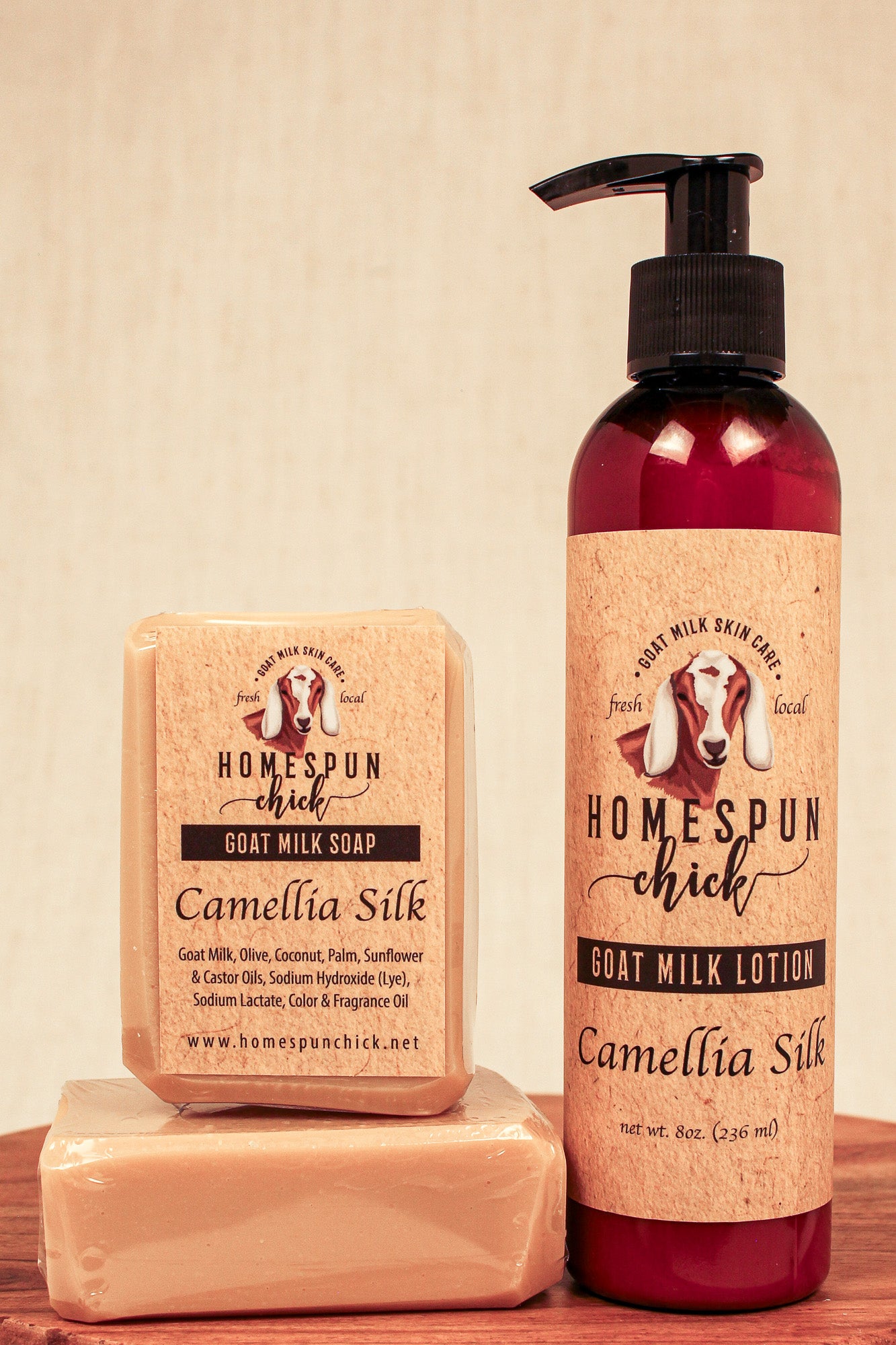 Homespun Chick goat milk soap and lotion on a wooden surface with a beige background