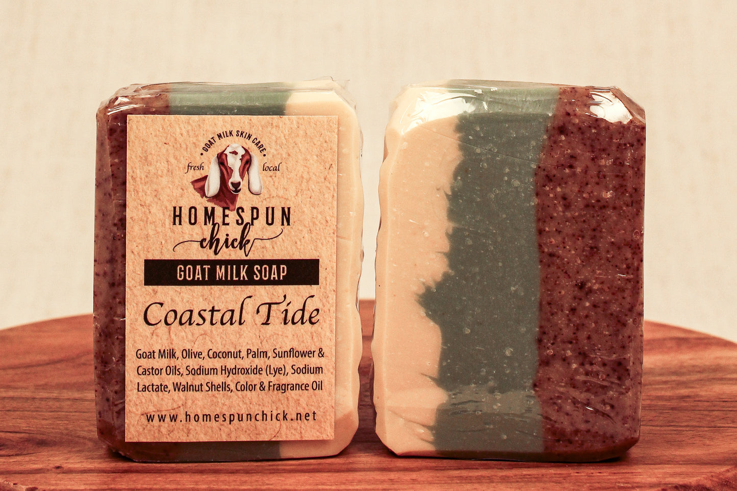 Two bars of soap, one with a label and the other plain, on a wooden surface.