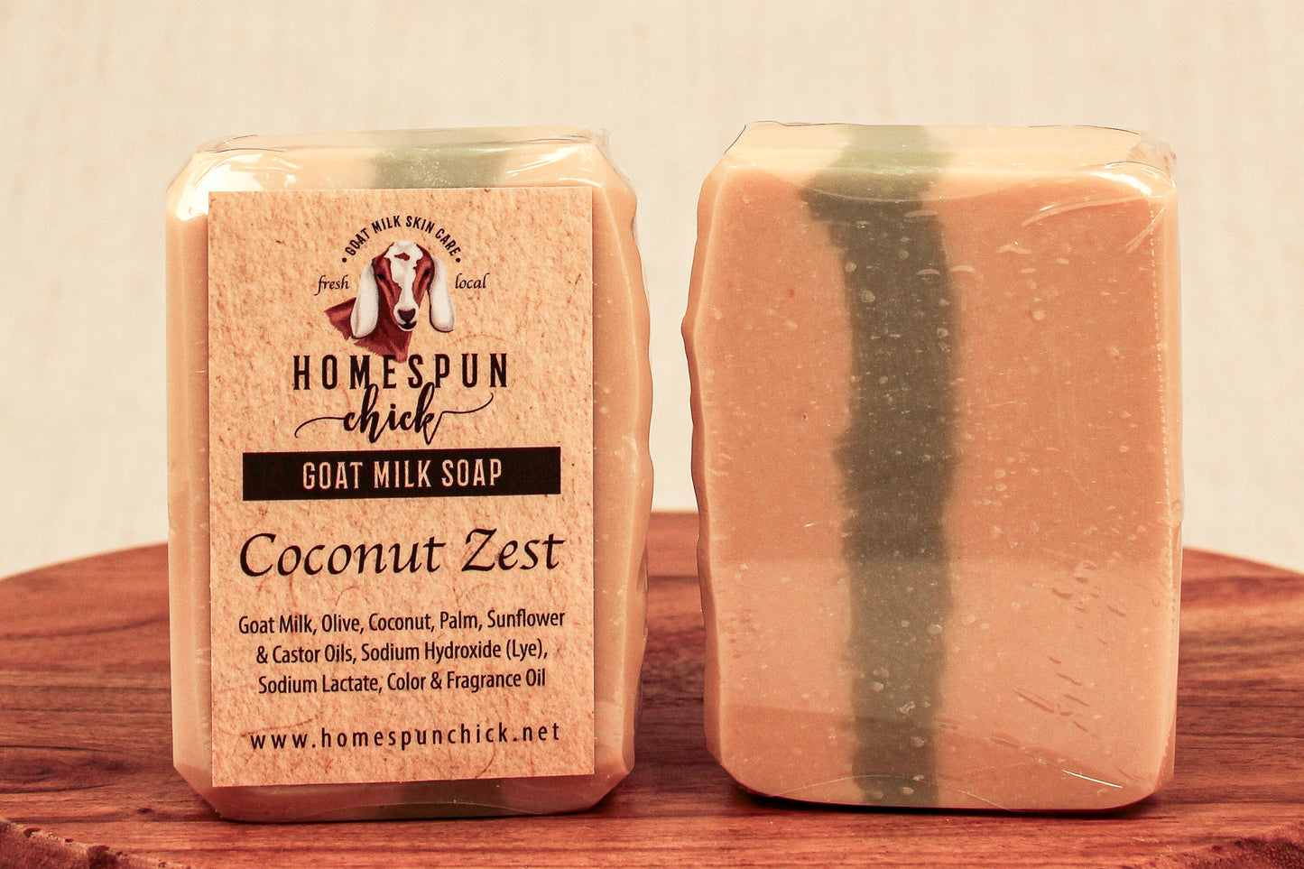 Goat milk soap bar with packaging labeled 'Homespun Chick Coconut Zest' on a wooden surface.