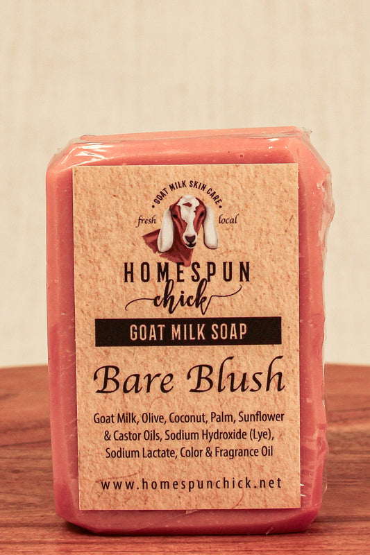 Bar of goat milk soap labeled 'Bare Blush' from Homespun Chick on a wooden surface.