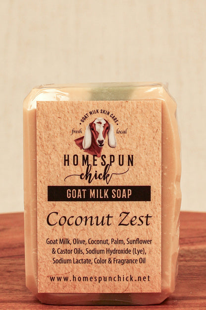 Goat milk soap bar with 'Homespun Chick' branding on a wooden surface.