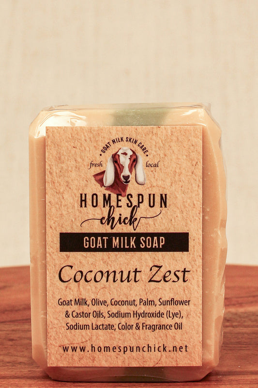 Goat milk soap bar with 'Homespun Chick' branding on a wooden surface.