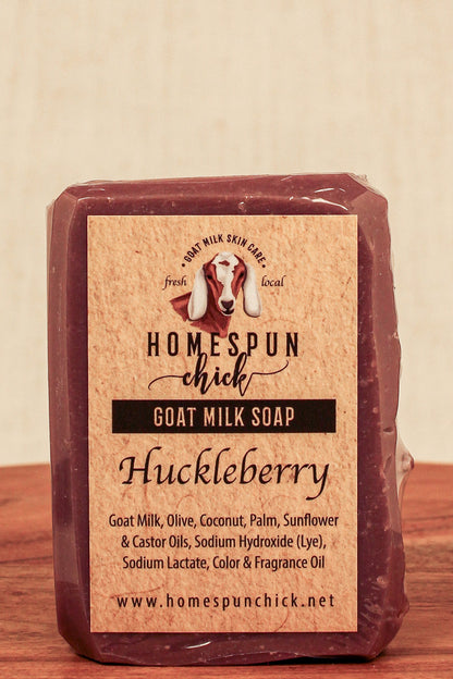 Bar of goat milk soap with 'Homespun Chick' label on a wooden surface