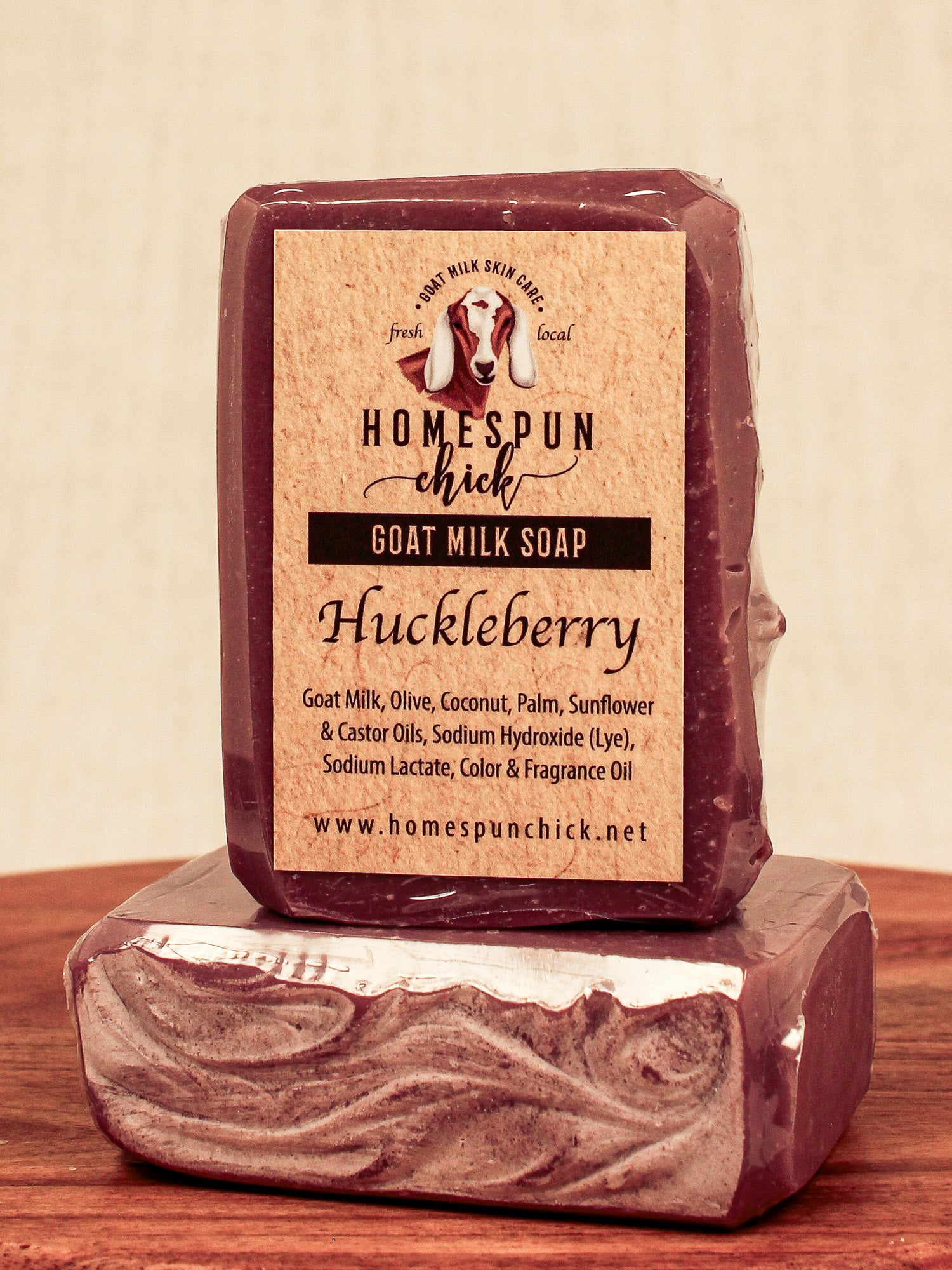 Bar of goat milk soap with 'Homespun Chick' label on a wooden surface