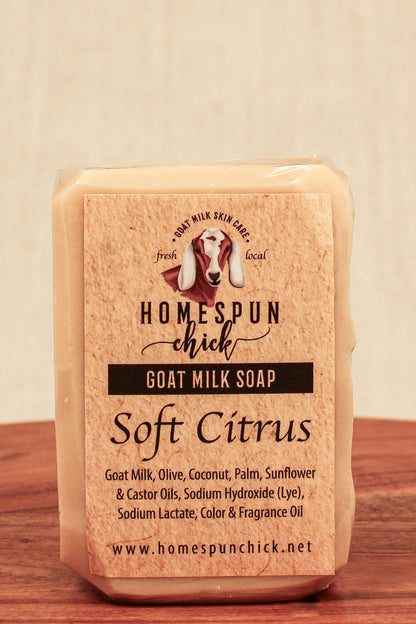 Bar of goat milk soap with 'Homespun Chick' branding on a wooden surface.