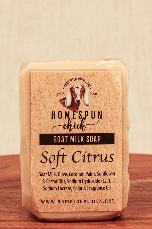 Bar of goat milk soap with 'Homespun Chick' branding on a wooden surface.