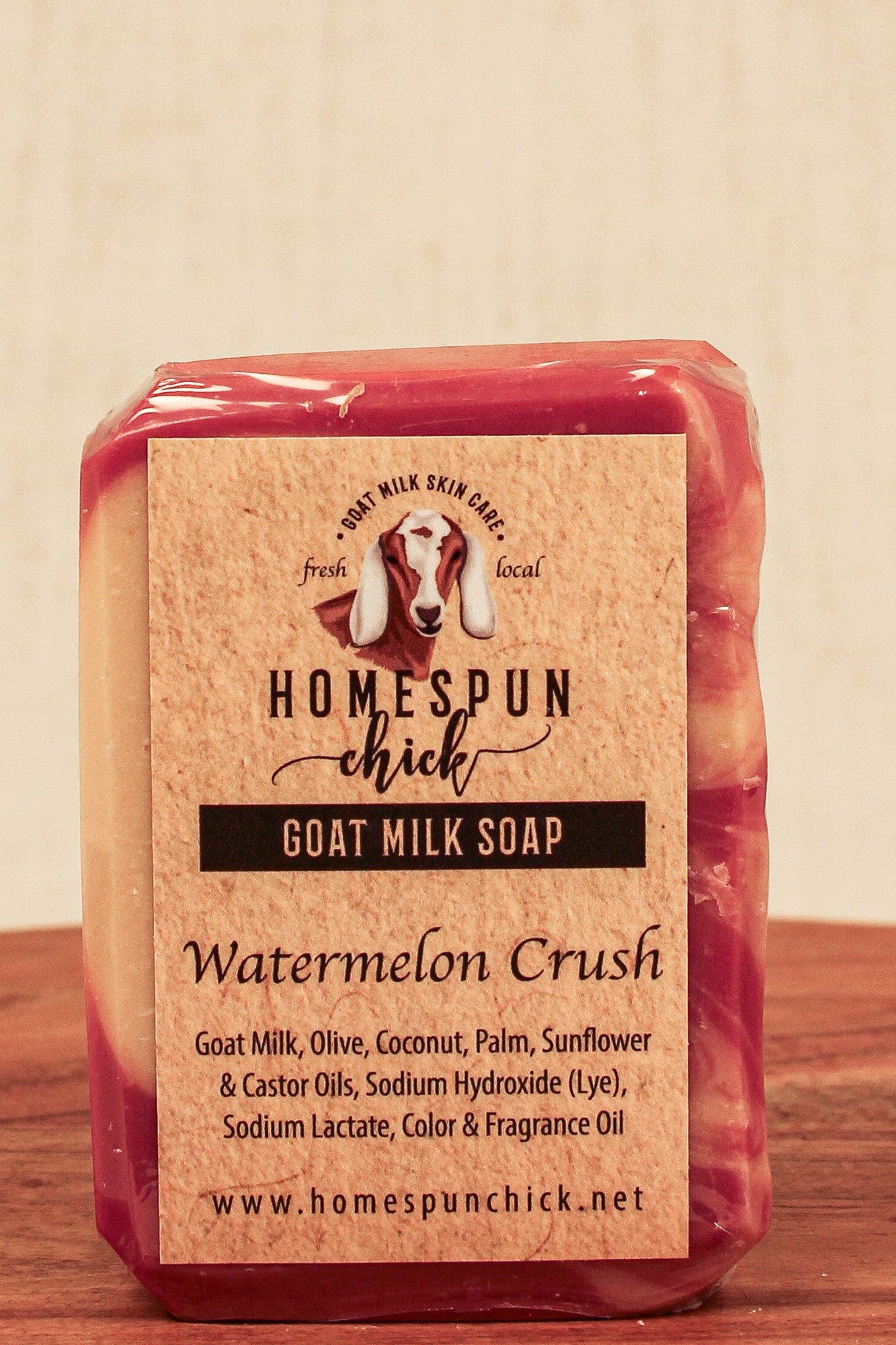 Packaged goat milk soap with 'Homespun Chick' branding on a wooden surface.