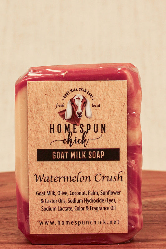 Packaged goat milk soap with 'Homespun Chick' branding on a wooden surface.