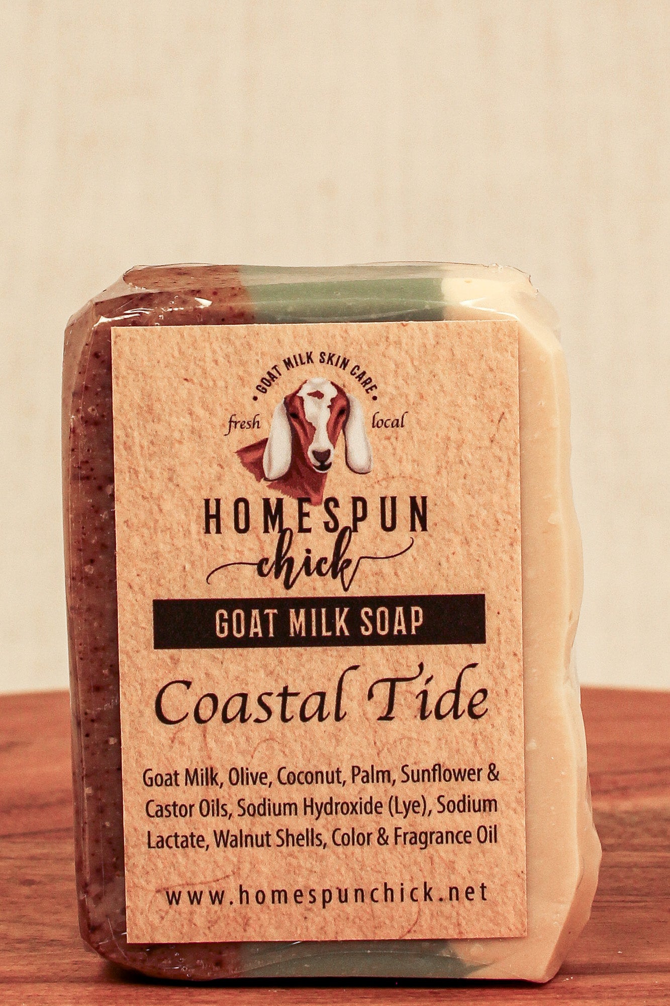 Goat milk soap bar with 'Homespun Chick' label on a wooden surface