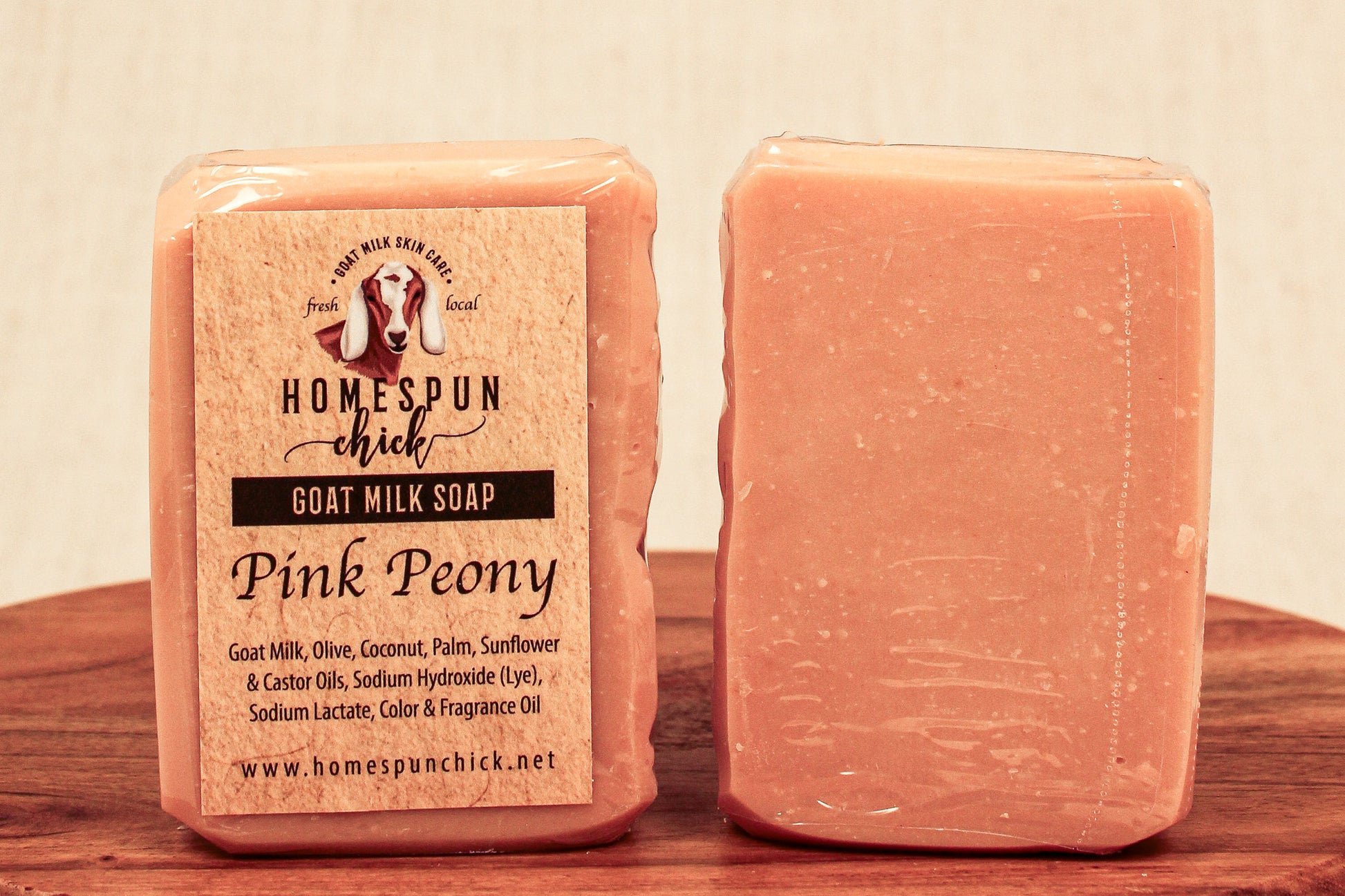 Pink Peony goat milk soap with a label on a wooden surface