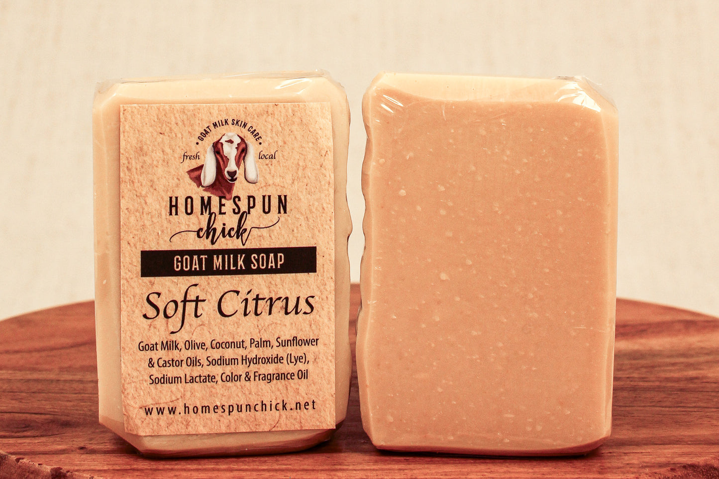 Two bars of soap with a 'Homespun Chick' label on a wooden surface.