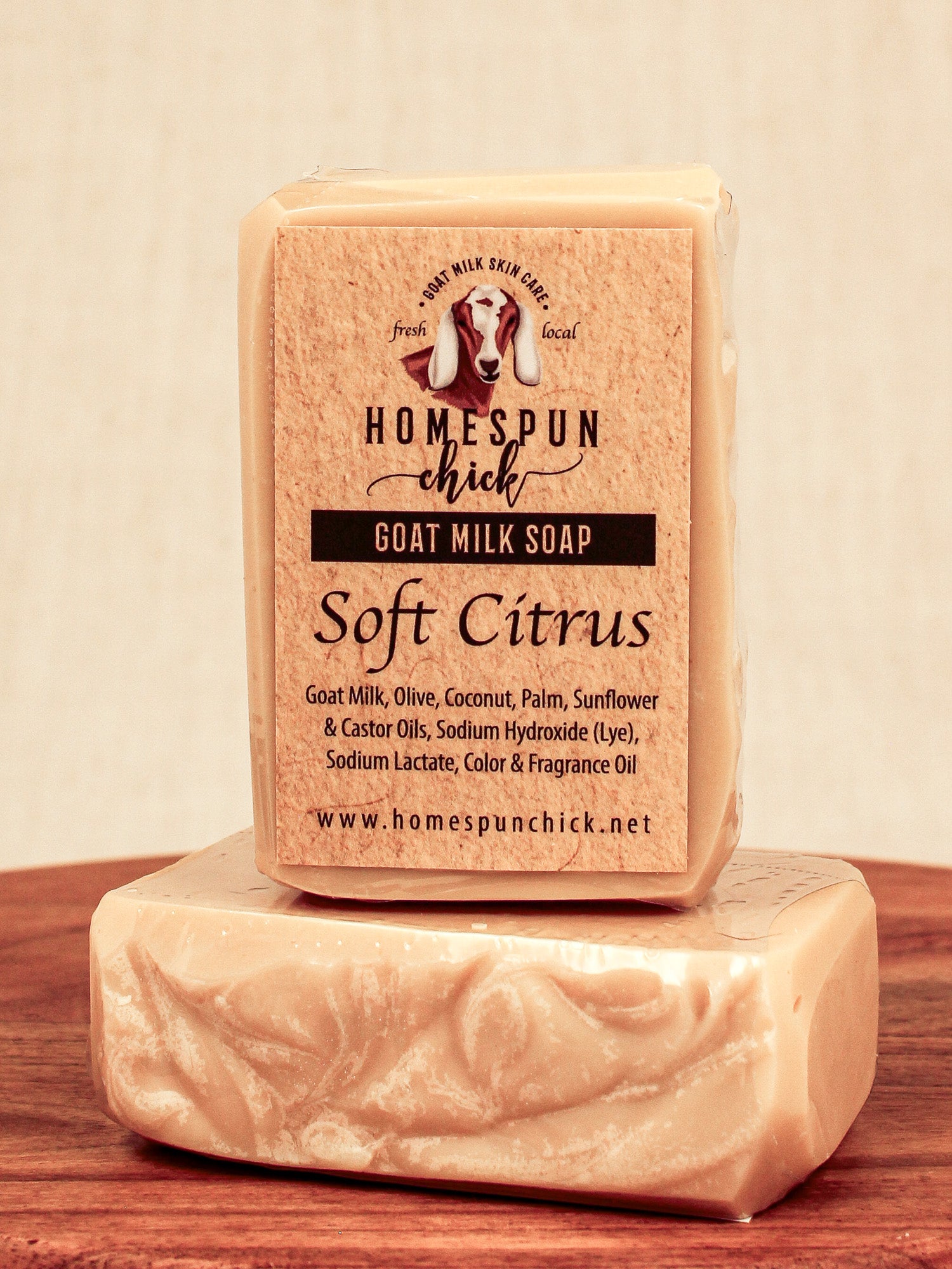 Bar of goat milk soap with 'Homespun Chick' branding on a wooden surface.